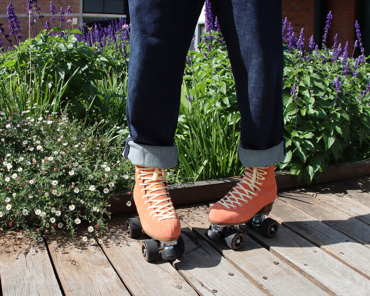 Chuffed Skates peach pink roller skates on boardwalk with lavender flowers behind